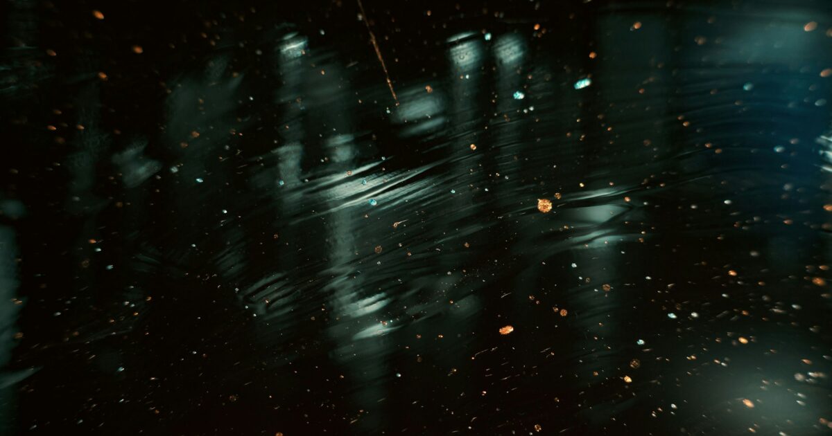 水面に反射する光と浮遊する粒子が幻想的な夜の風景